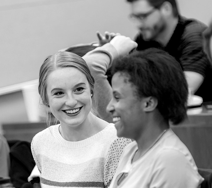 A recent graduate employee speaking with a coworker.